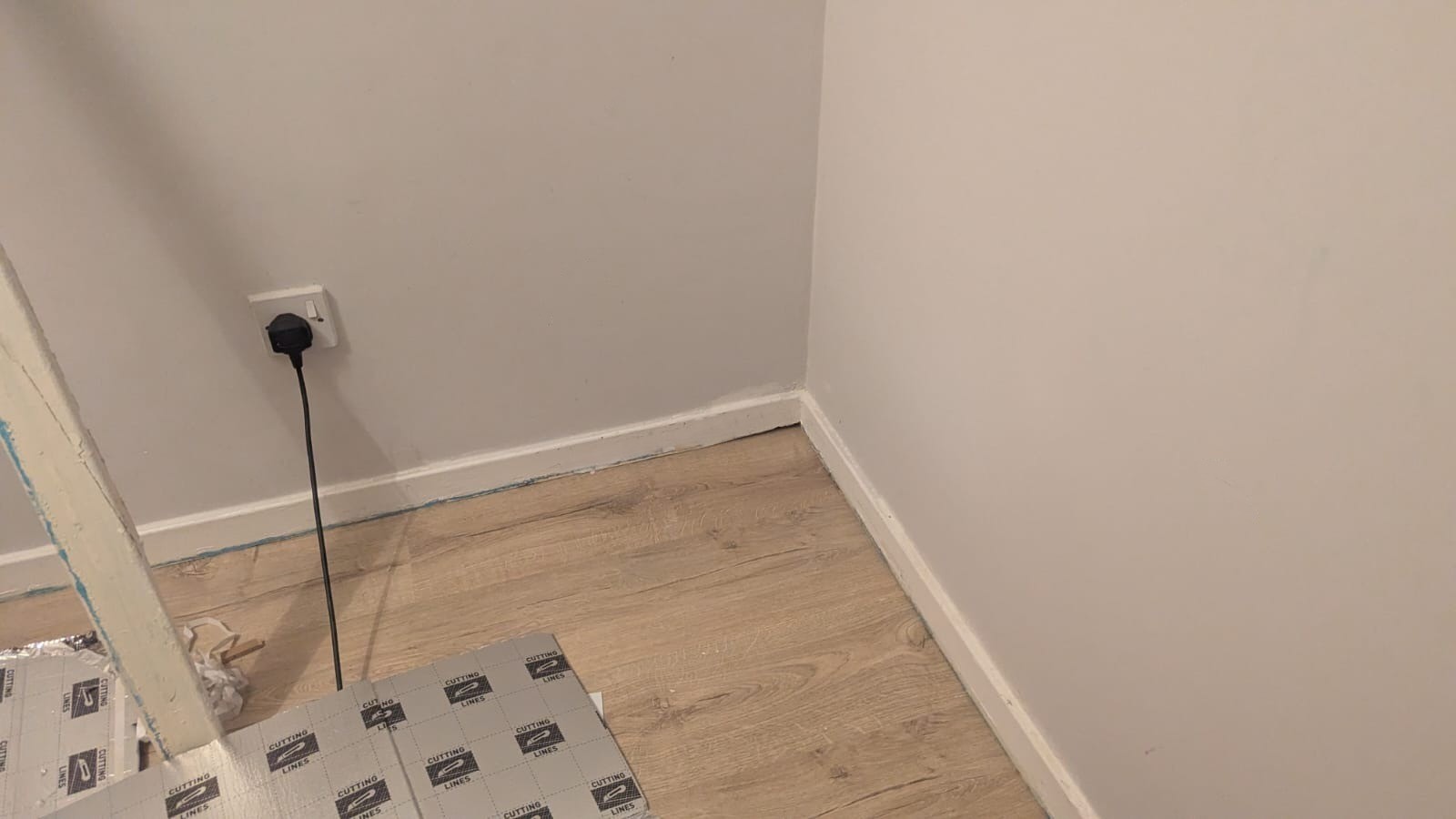 An image of laminate flooring near the end of the installation process by Tall Joiner.